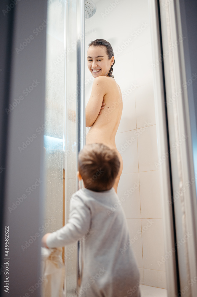Toddler looking at mom taking shower