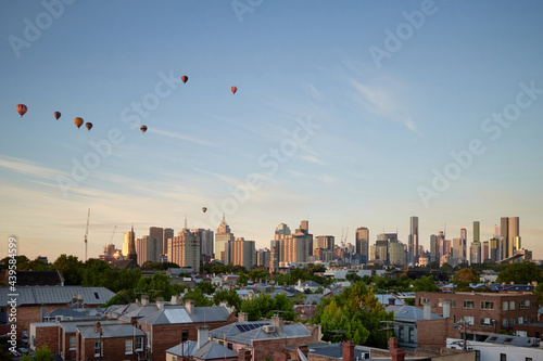 Melbourne city skyline at dawn with hot air balloons passing over photo
