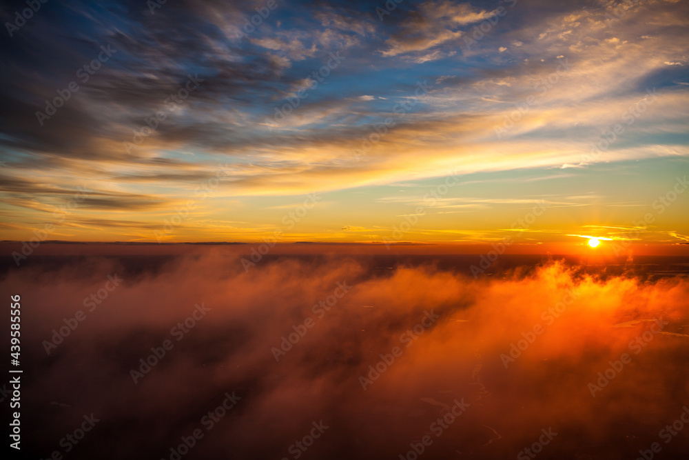 Sunset above the clouds captured from a motorized paraglider