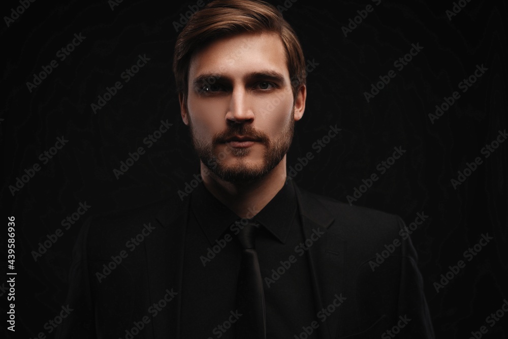Fototapeta premium Elegant young handsome man in black suit. Studio fashion portrait