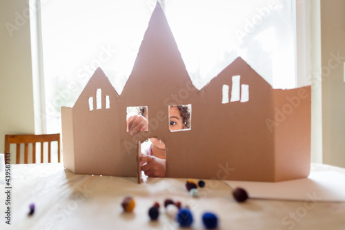 Girl decorates cardboard castle
 photo