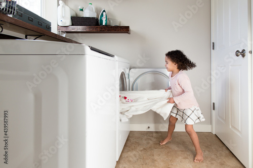 Girl yanks on towel in dryer photo