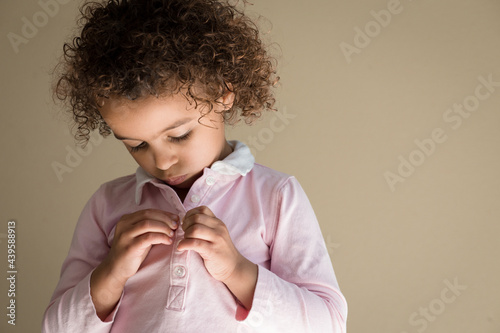 Girl fastens tiny shirt buttons photo
