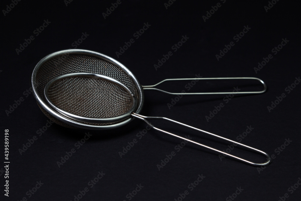Kitchen sieve on a black background. Small steel sieve Kitchen sieve on a black background. Small steel sieve