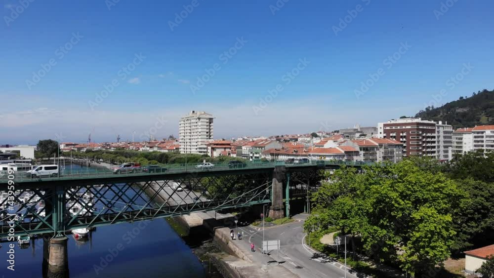 Viana do Castelo, Portugal - June 10, 2021: DRONE AERIAL FOOTAGE - Gustave Eiffel Bridge over the river Lima in Viana do Castelo. Aerial panoramic cityscape view of Viana and the Marina. Viana do Castelo, Portugal - June 10, 2021: DRONE AERIAL FOOTAGE - Gustave Eiffel Bridge over the river Lima in Viana do Castelo. Aerial panoramic cityscape view of Viana and the Marina.