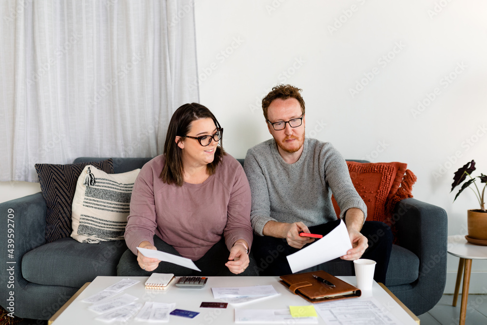 Middle Aged Couple Closing in on Finished Their Annual Tax Preparation Middle Aged Couple Closing in on Finished Their Annual Tax Preparation