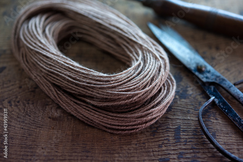 Close up of old style twine or string used in leather craft,  with vintage scissors. Shallow depth of field.