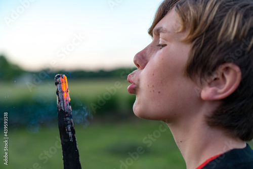 Boy blowing embers