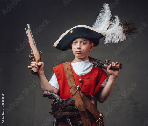 Serious kid buccaneer with handguns and tricorn