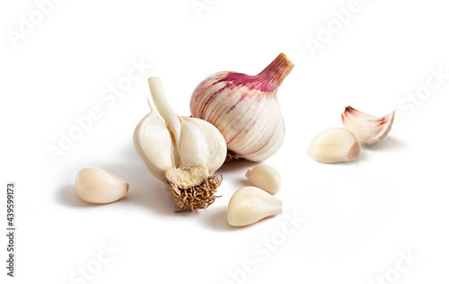Fresh green garlic groups and peeled cloves are isolated on a white background.