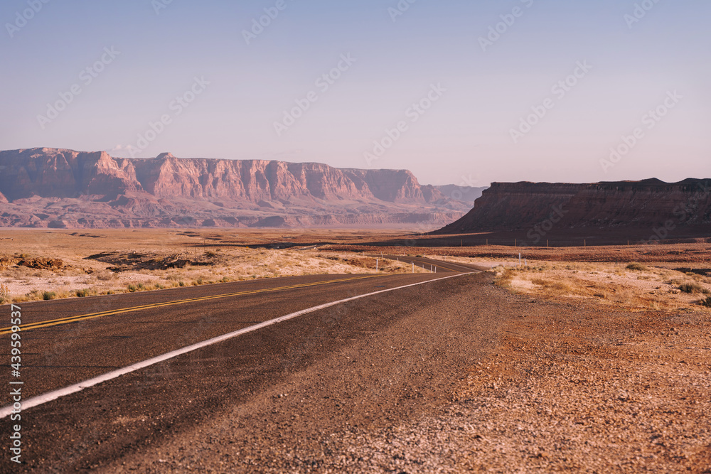 A picturesque empty road in Arizona through a desert of red rocks and rocks