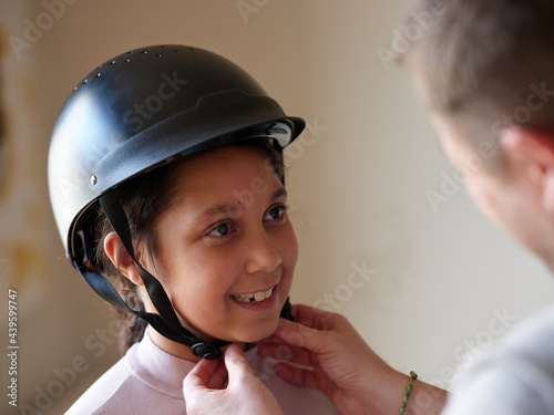 Father helping daughter with safety helmet