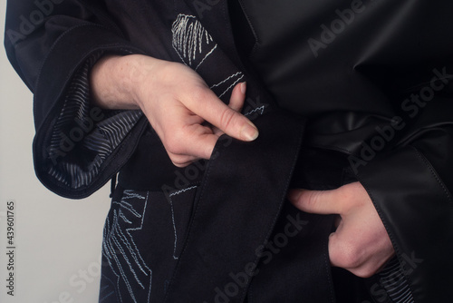 Woman hands cinching her coat