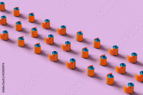 Orange film rolls on pink background neatly arranged
