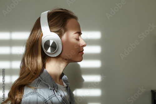 Woman listening to music in headphones at home photo