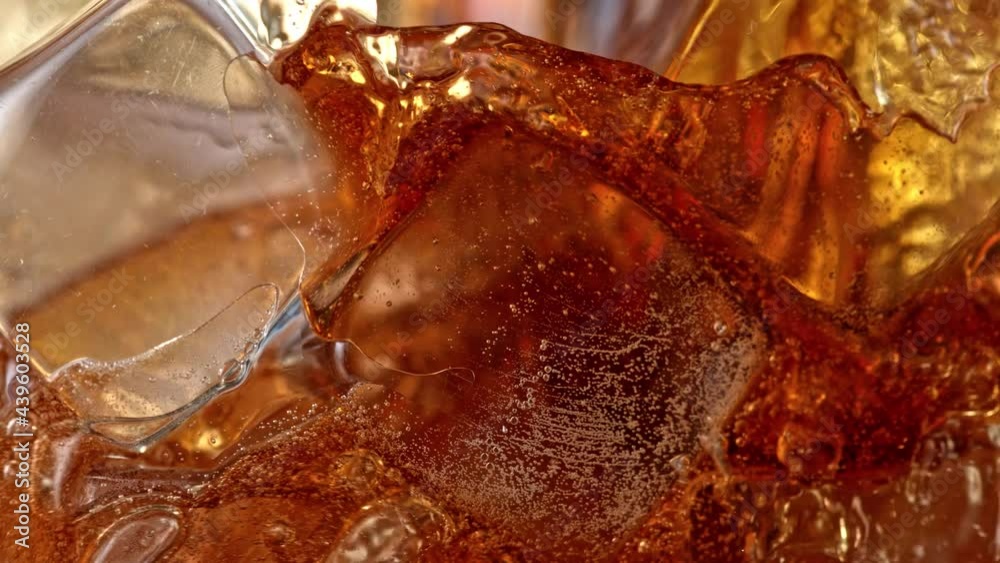 Super Slow Motion Detail Shot of Pouring Cola Lemonade into Glass with Ice Cubes at 1000 fps. Super Slow Motion Detail Shot of Pouring Cola Lemonade into Glass with Ice Cubes at 1000 fps.