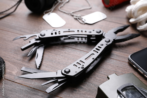 Modern compact portable multitool and accessories on wooden table