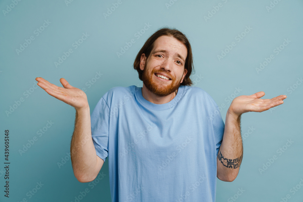 Young ginger man with beard smiling and holding copyspace Young ginger man with beard smiling and holding copyspace