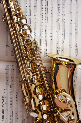 closeup of gold saxophone on sheet music