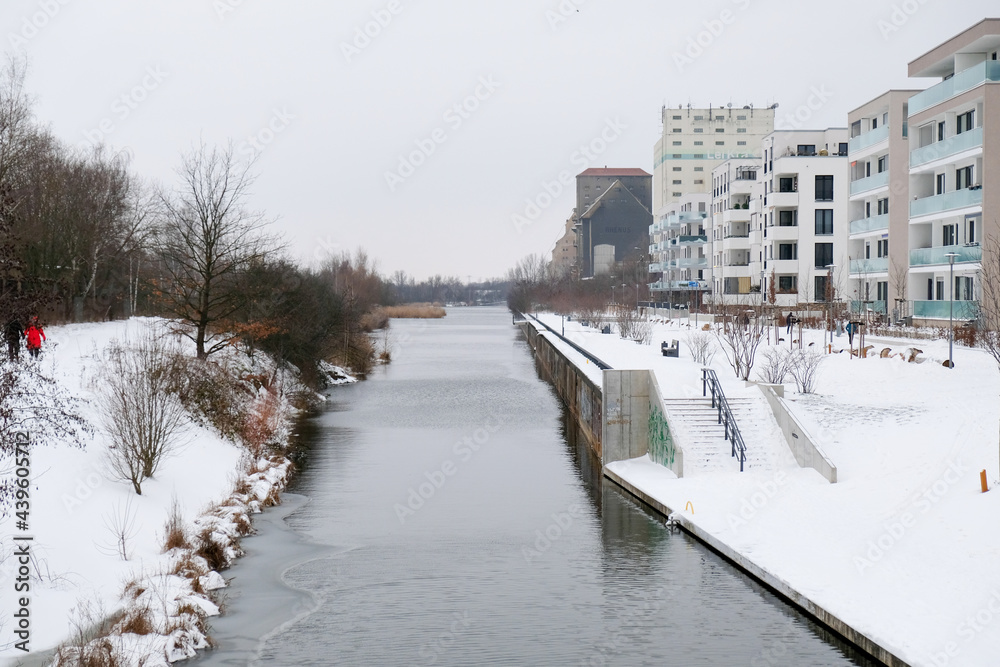 The partly frozen canal in Leipzig with lots of snow on the banks.