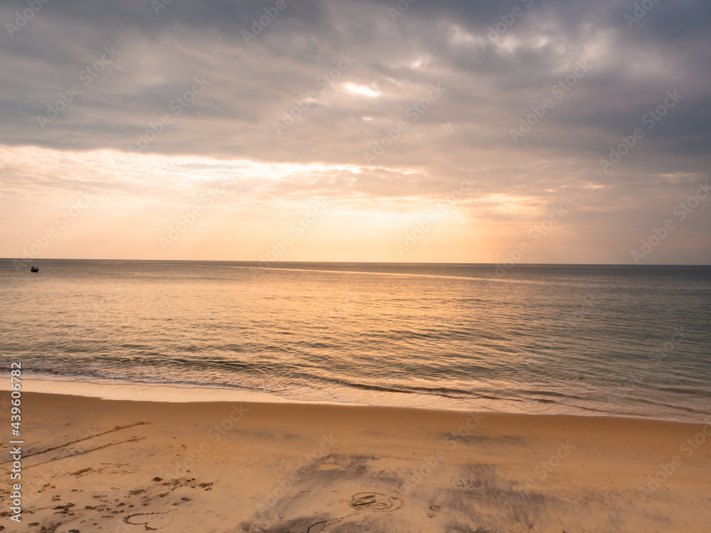 adstract color of yellow beach in golden sunset at the beach. dramatic gray cloudy sky above sea water