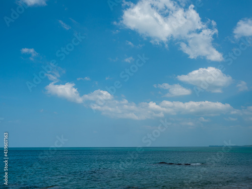 blue sky fluffy white clouds above the ocean. horizon at sea. © phoomrat