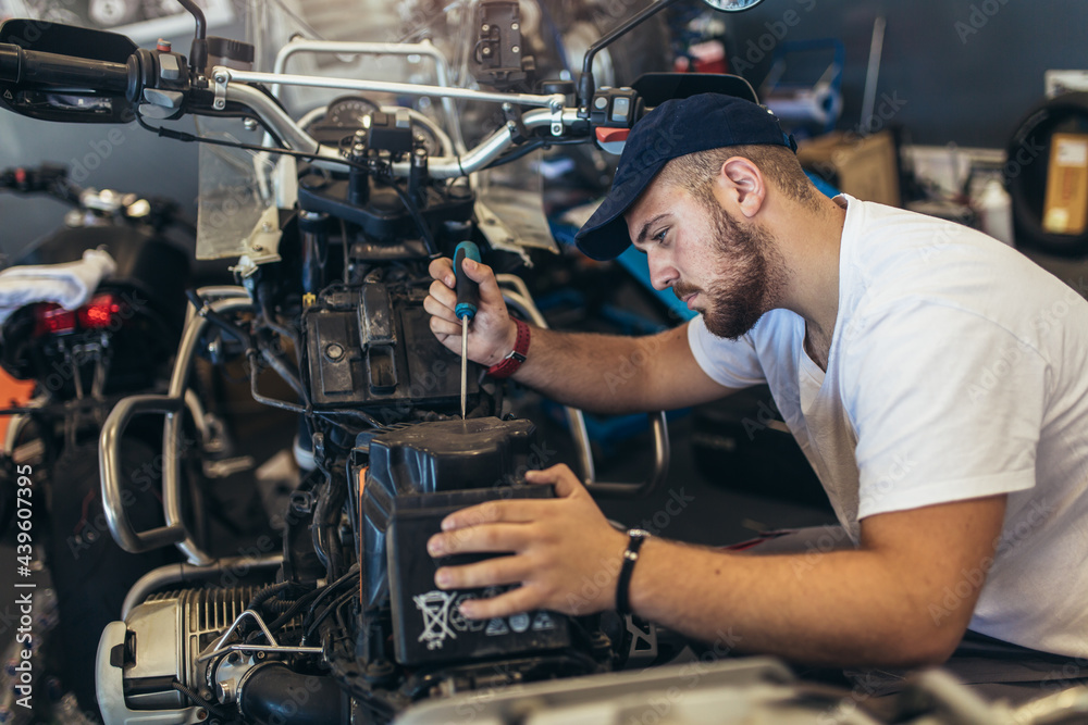 Professional motorcycle mechanic working in bike repair service Professional motorcycle mechanic working in bike repair service