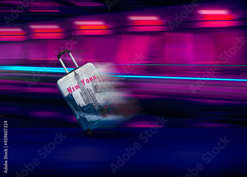 Suitcase with New-York design rolling fast in the night