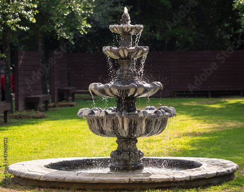 stone water fountain in a garden with water splashing