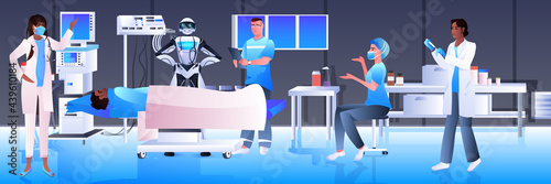 surgeons with robotic assistant making operation to patient lying on bed emergency medical treatment