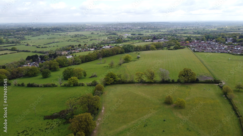 An aerial view of some parkland with housing and countryside in the background