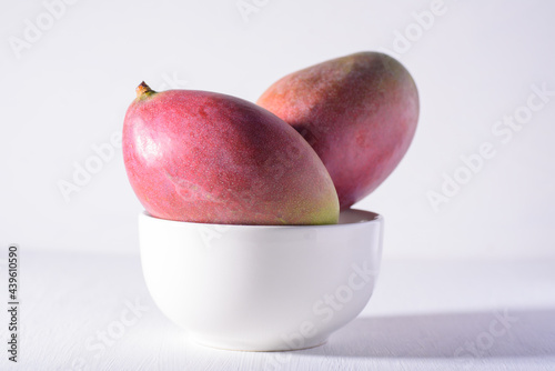 Fresh palmer mango fruit in bowl on white background, Tropical fruit	 photo