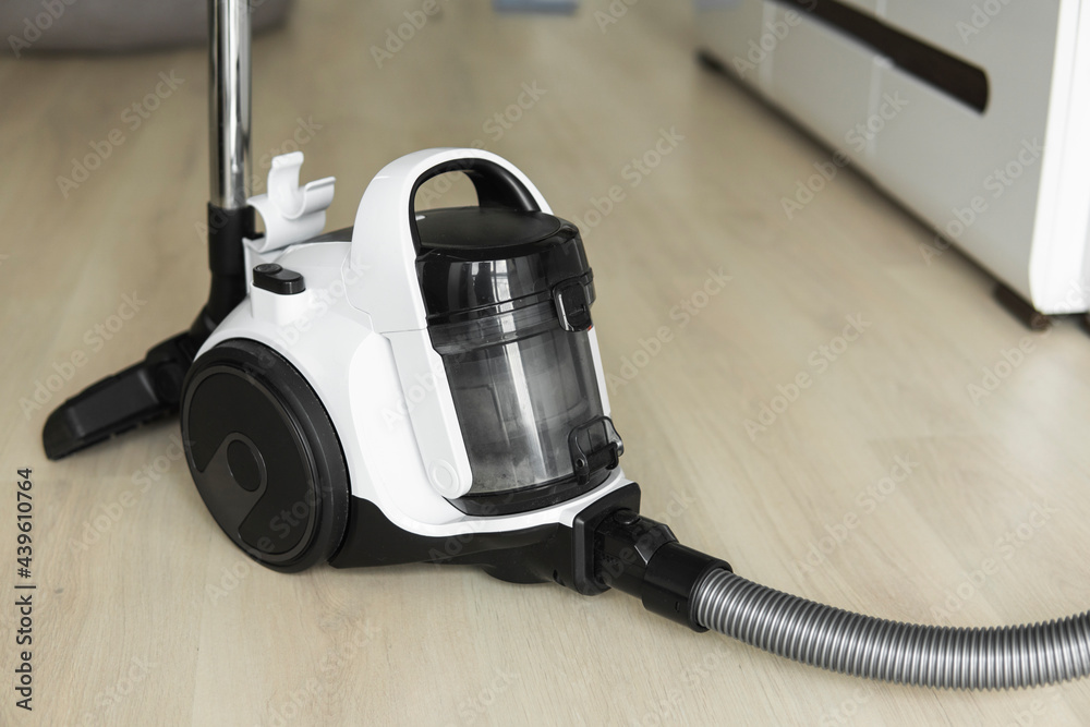 Bagless cyclone vacuum cleaner on a laminate. Electrical apparatus that by means of suction collects dust and small particles from floors and other surfaces.