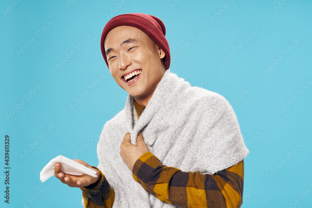 Asian man with a scarf on his hands covered with a blanket Asian man with a scarf on his hands covered with a blanket