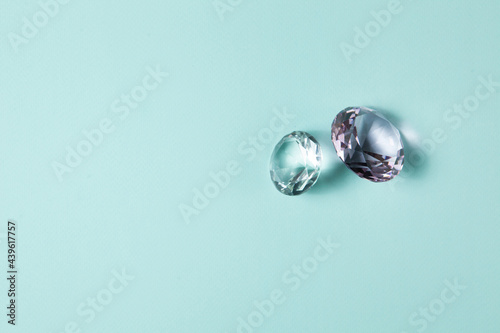 Precious gemstones for design gems jewellery. Diamonds crystal on turquoise background.