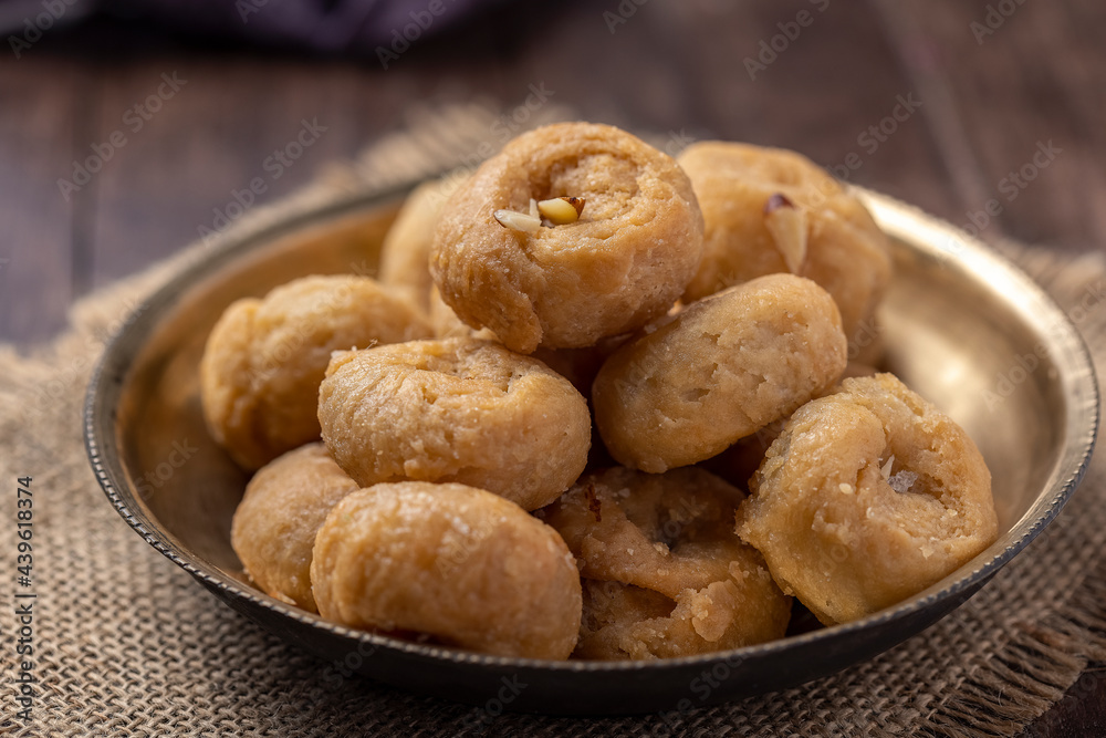 Indian traditional sweet balushahi served on a metal plate on wooden background
