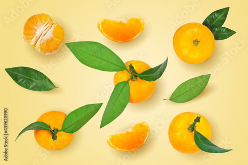 Fototapeta Naklejka Na Ścianę i Meble -  Tangerine or mandarin fruit with leaves isolated on yellow background.