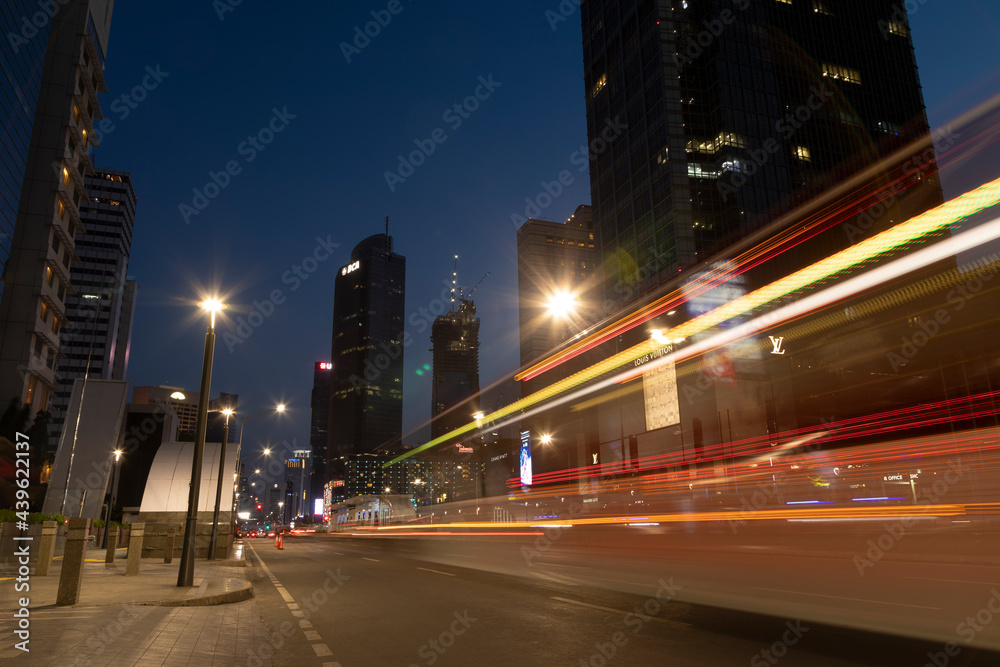 Night traffic lights in downtown Jakarta, between office skyscrapers, Thamrin street