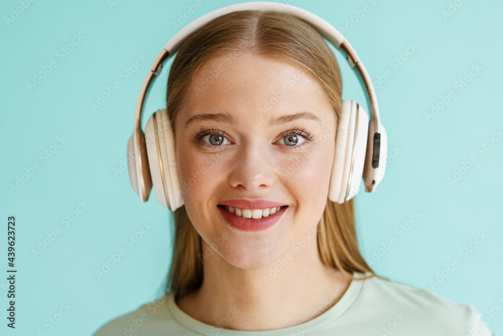Young blonde white woman in headphones smiling at camera Young blonde white woman in headphones smiling at camera