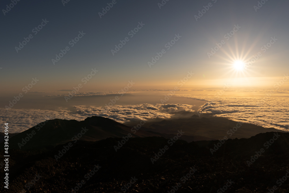 Fototapeta premium Sunset view from el Teide volcano, Tenerife canary island Spain. Silhouette people. Sun above clouds 