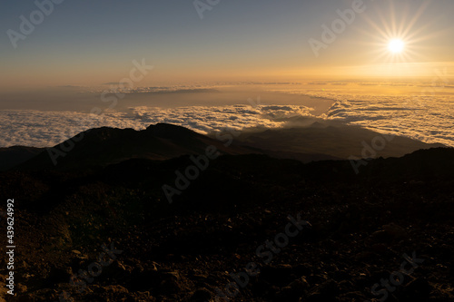 Sunset view from el Teide volcano, Tenerife canary island Spain. Silhouette people. Sun behind clouds 