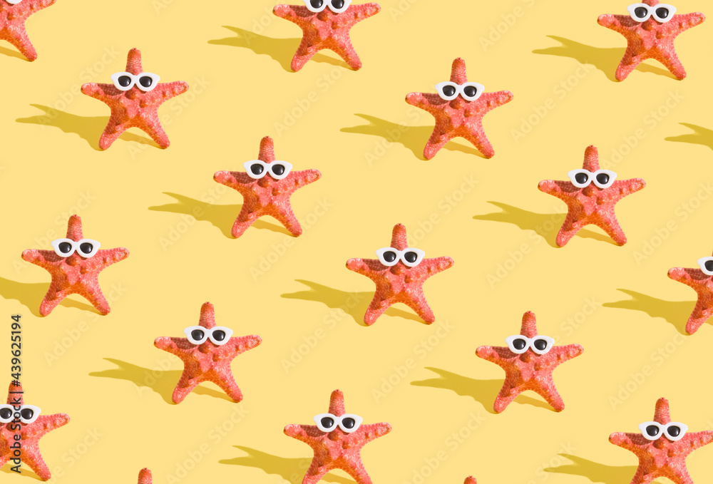 Pattern from starfish in sunglasses on a yellow background. Minimalistic humorous summer background