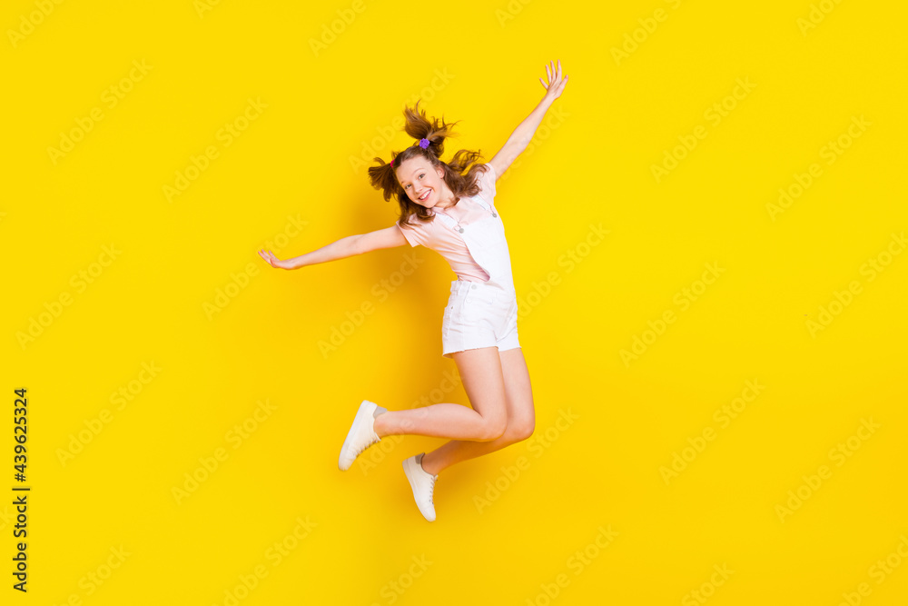 Full length body size view of attractive funky cheerful girl jumping having fun good mood isolated over bright yellow color background