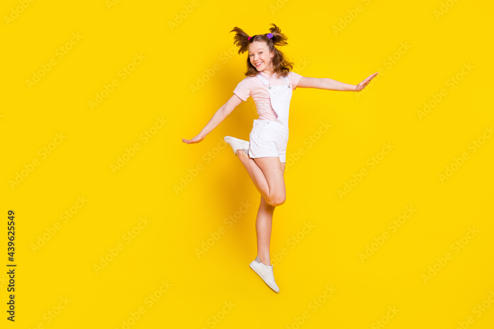 Full length body size view of attractive girlish cheerful girl jumping posing good mood isolated over bright yellow color background