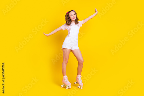 Full length body size photo schoolgirl dancing wearing rollers isolated bright yellow color background