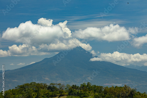 View of Klabat volcano  the highest volcano in Sulawesi  and the surrounding rainforest landscape  wrapped in white clouds  Indonesia