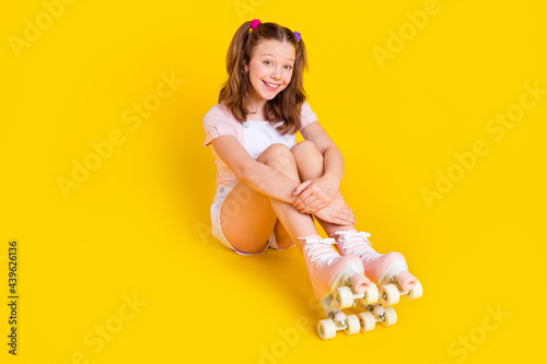 Full length body size photo schoolgirl wearing rollers smiling cheerful happy isolated bright yellow color background photo