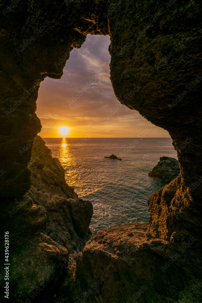 Sunset from cave in north Tenerife with view on sun and ocean
