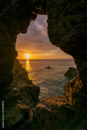 Sunset from cave in north Tenerife with view on sun and ocean