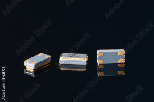 Electronic components close-up. Marco of oscillator crystal on black background.